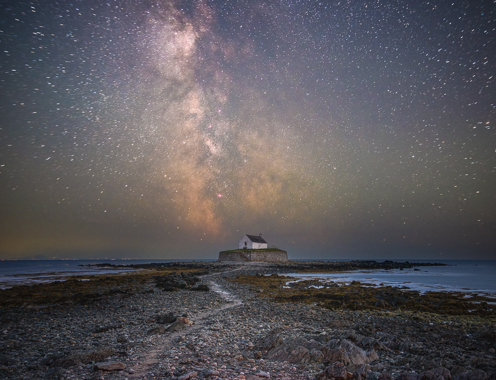 A small church by the sea under a starry sky and the Milky Way