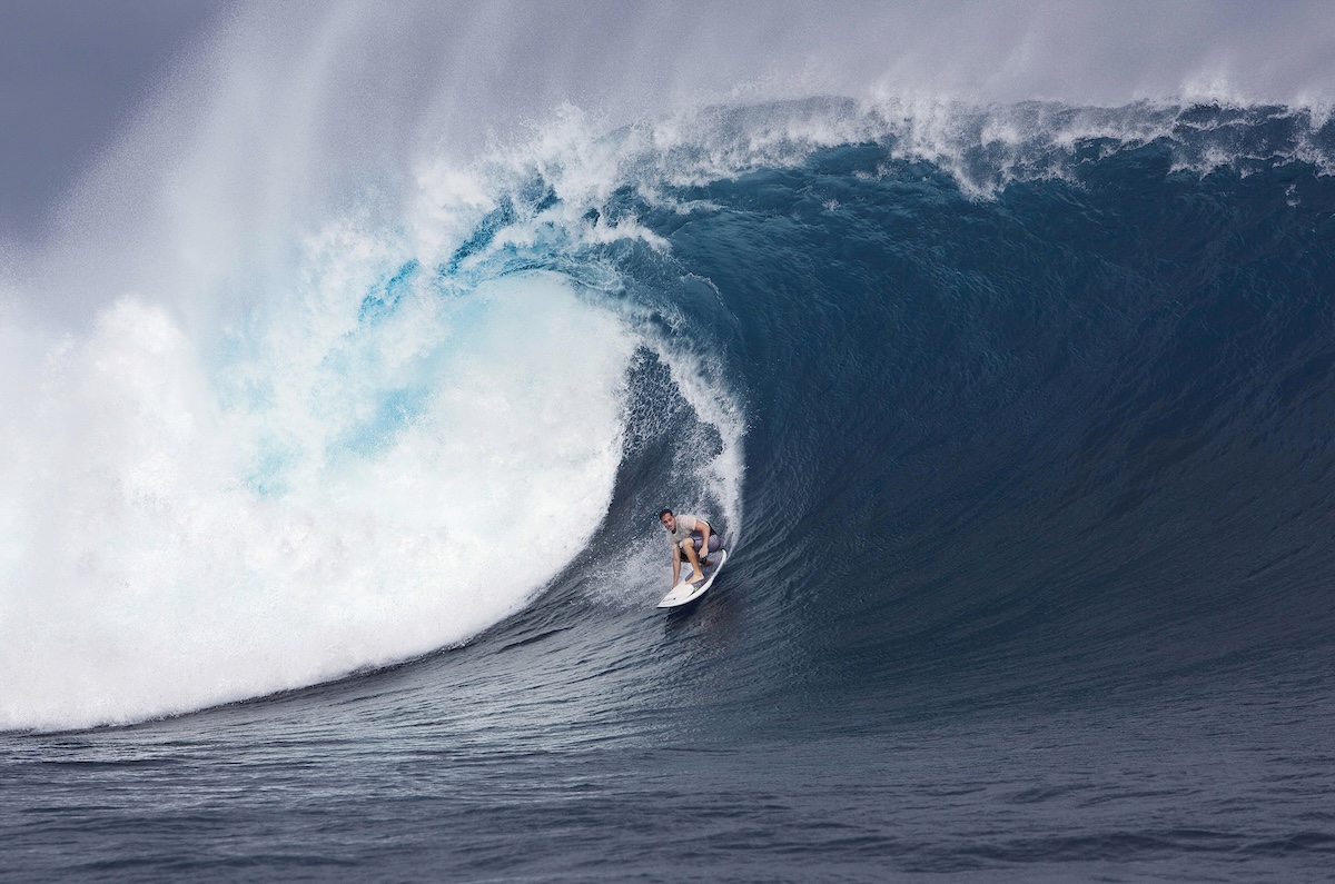 Surfer riding inside a huge curling ocean wave