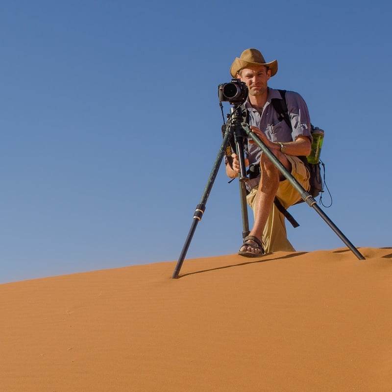 Man with a camera on a tripod in the desert