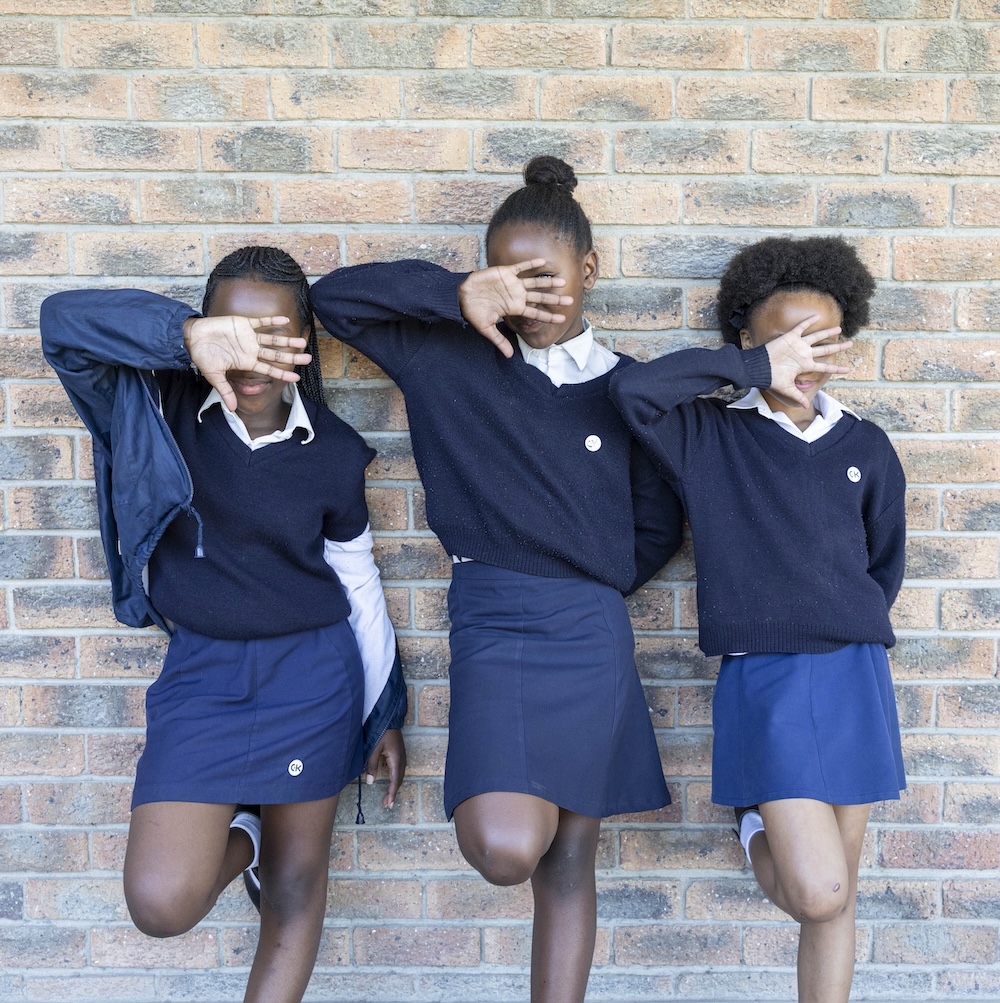 Three schoolgirls in uniform posing playfully